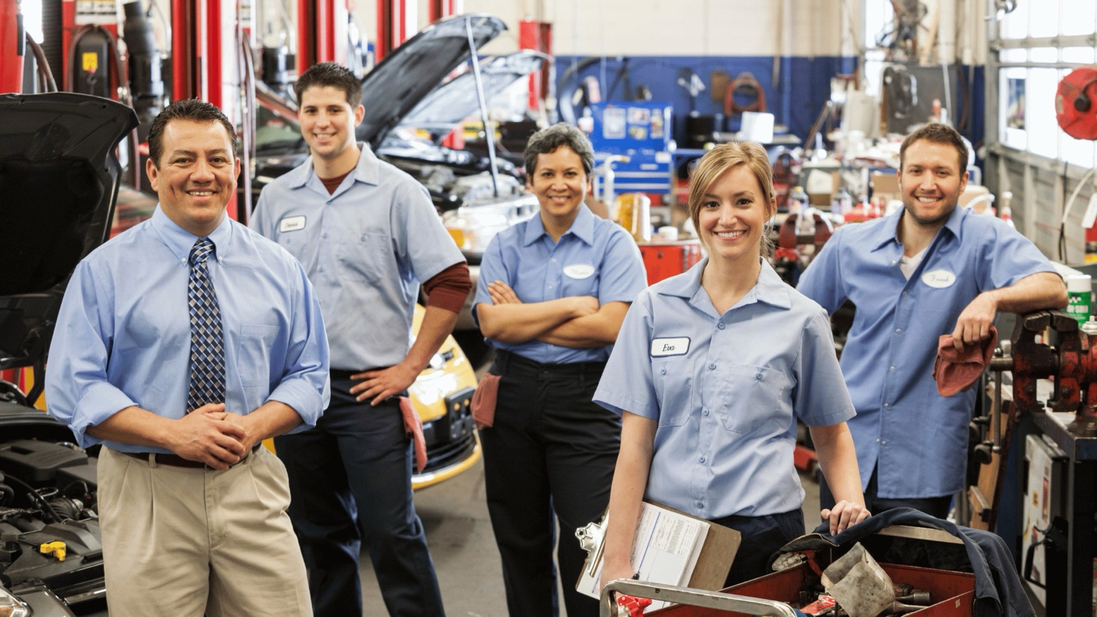 A dealership service team standing in the shop bays